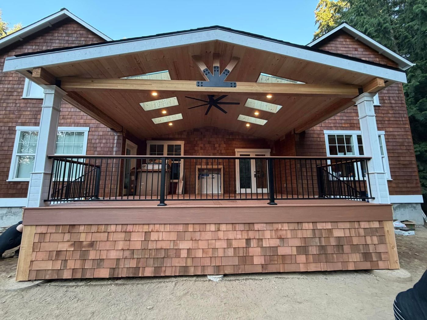 Covered porch on a shingled Bainbridge Island house with recessed ceiling lighting and a fan