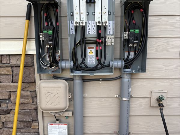 A 320 amp meter main with two 200 amp disconnects mounted either side on a house exterior